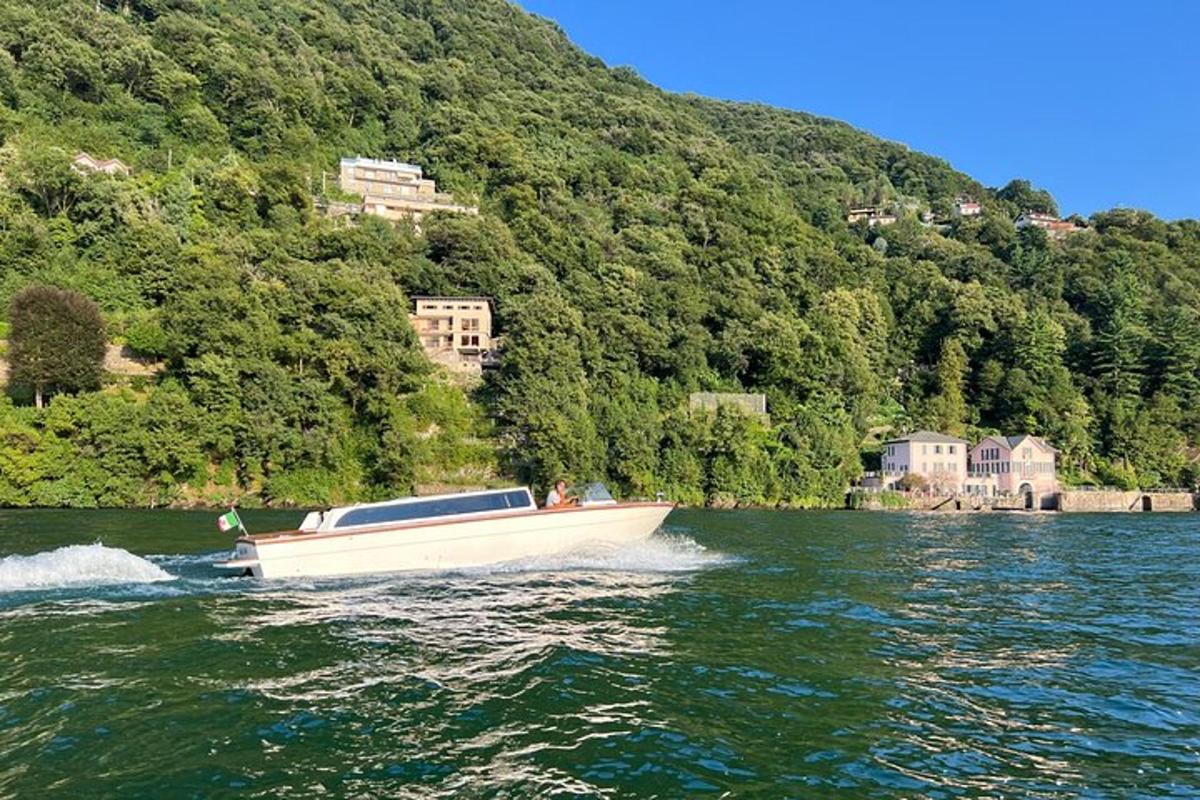 un barco blanco en el agua cerca de una montaña