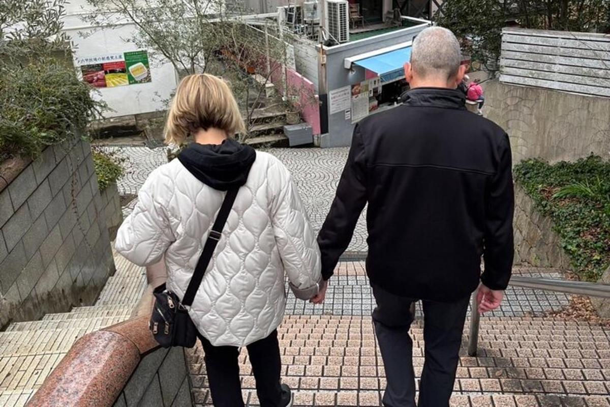 muž a žena jdoucí po chodníku držící se za ruce