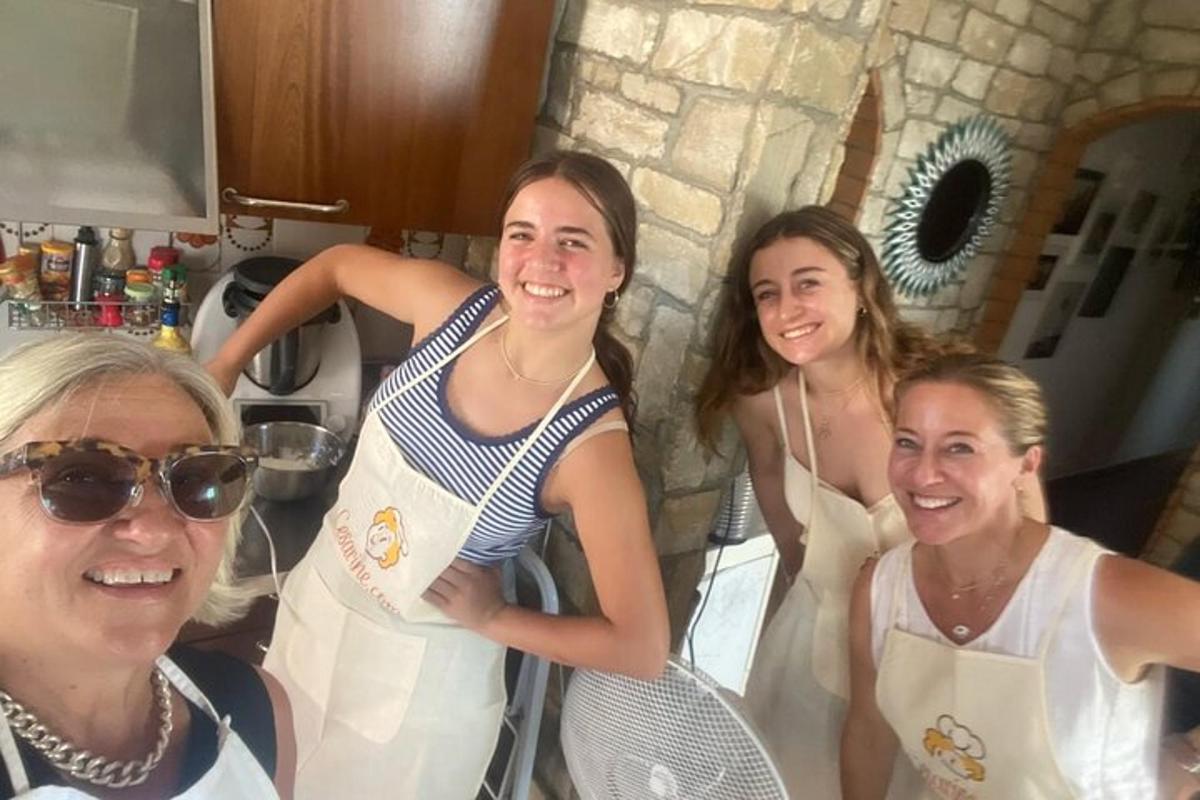 un gruppo di donne in piedi in una cucina con in mano delle racchette da tennis