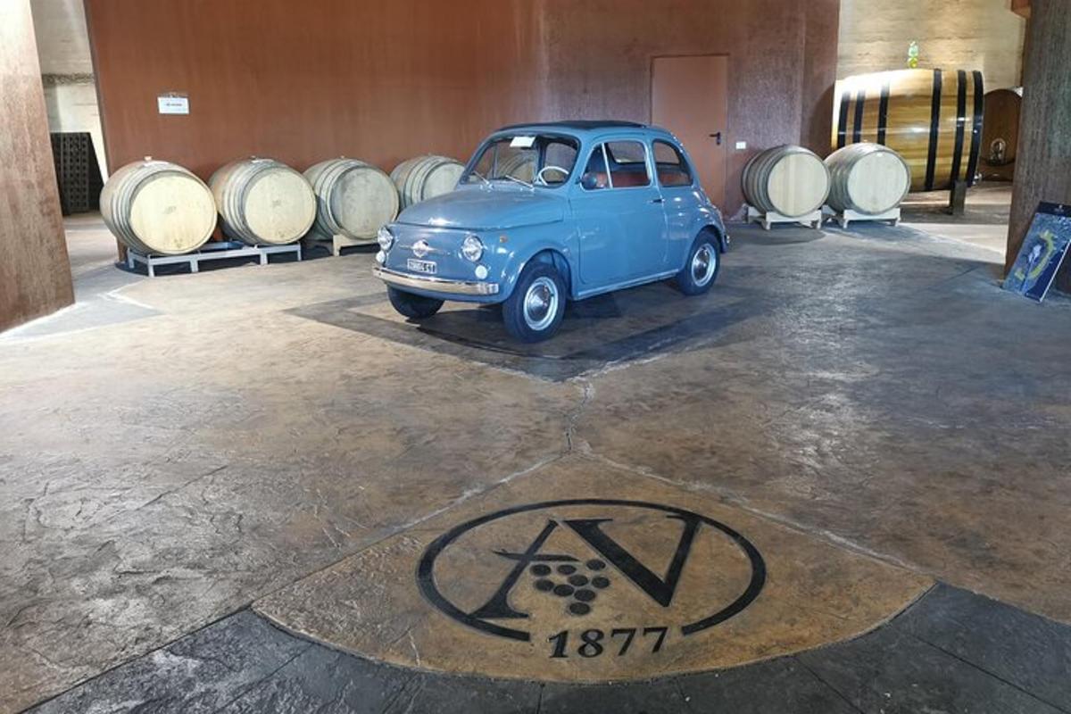 un'auto blu parcheggiata in una stanza con dei barili