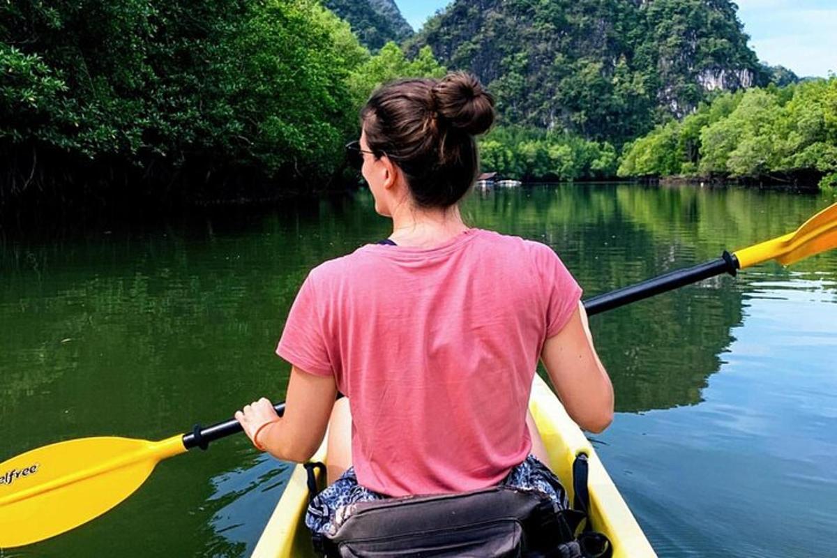 seorang wanita duduk di dalam kayak di atas air