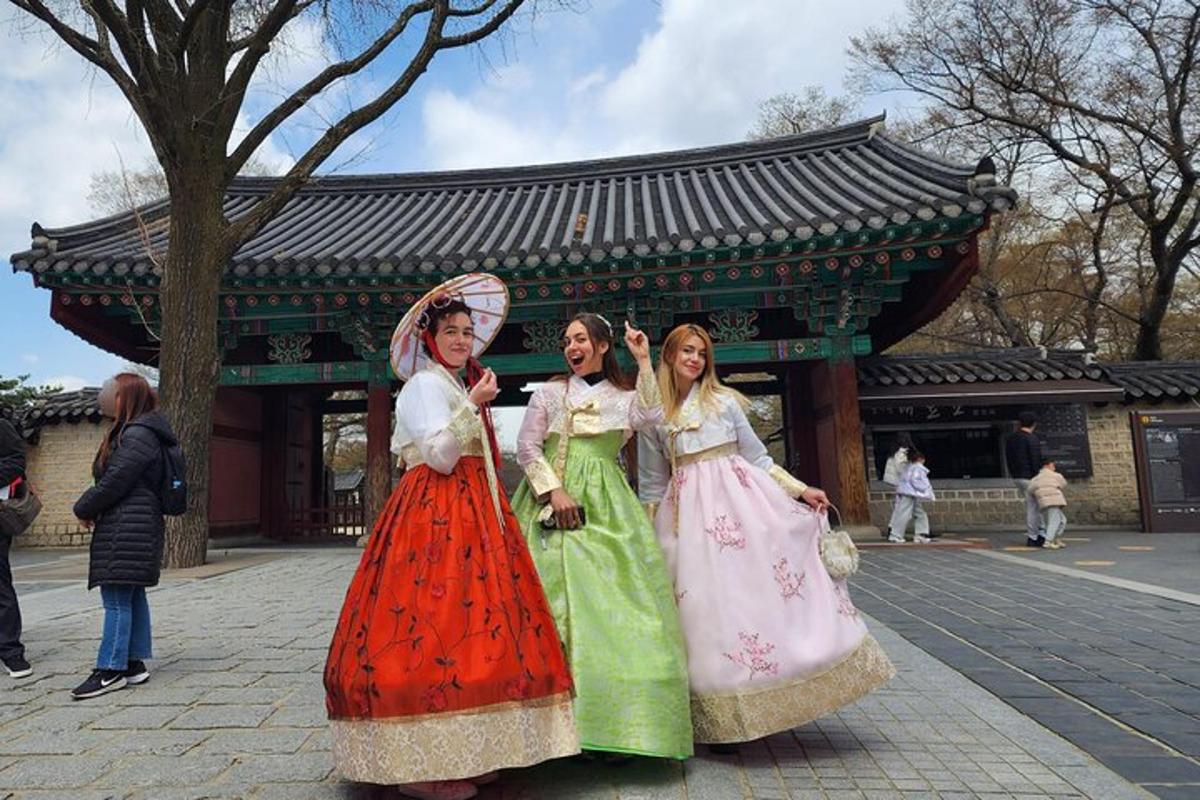 three girls in dresses standing in front of a building