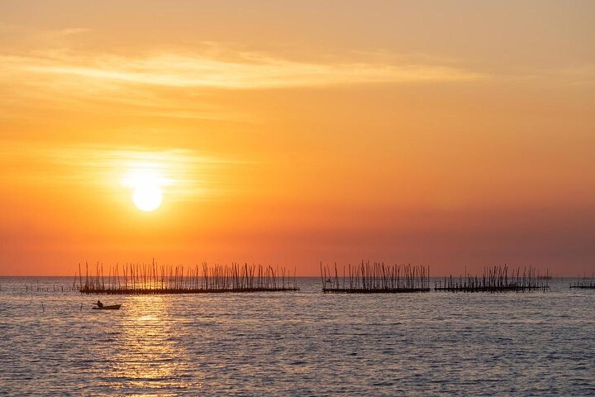 Loď v oceánu při západu slunce s molem