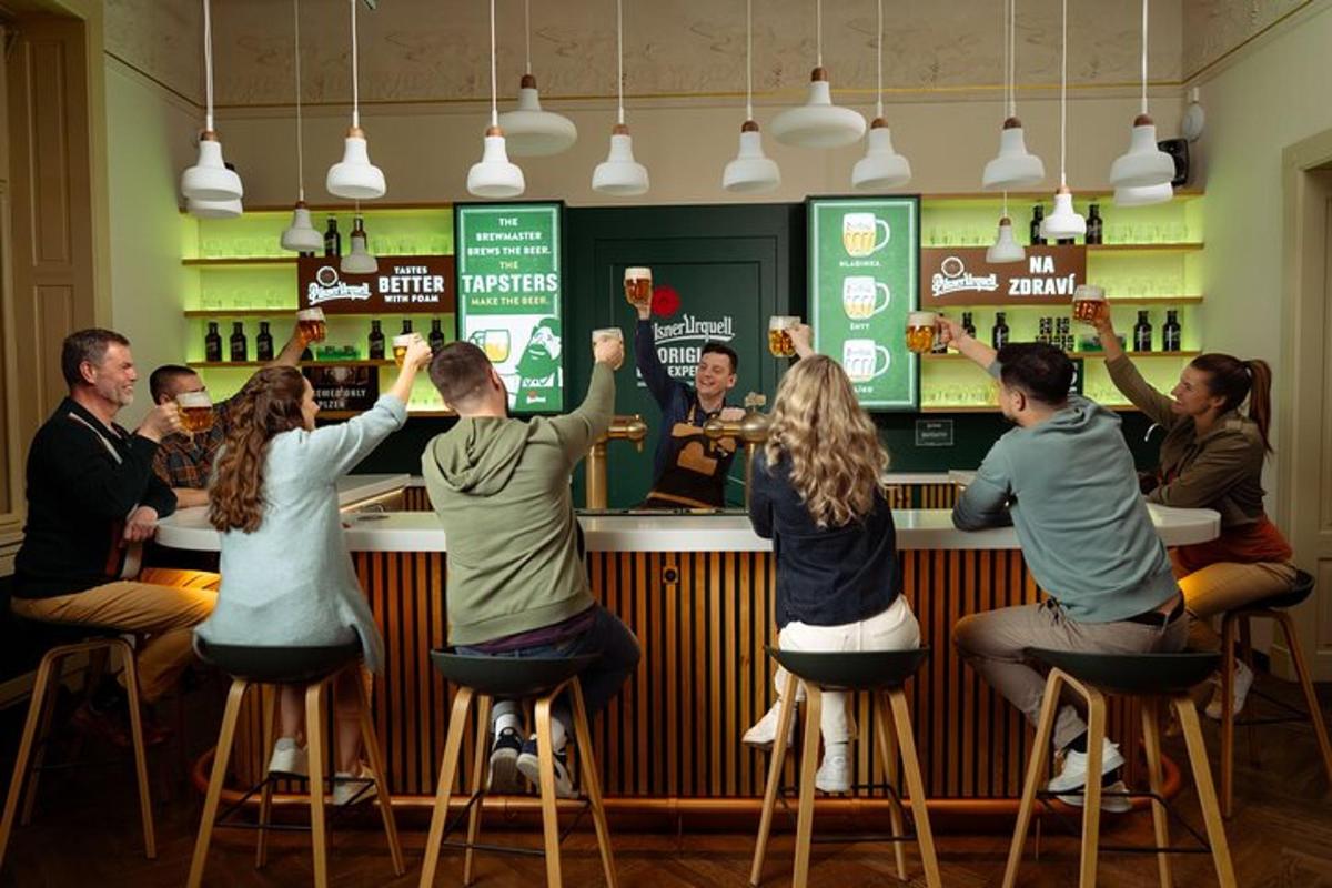 hópur fólks situr við bar og réttir upp hendur