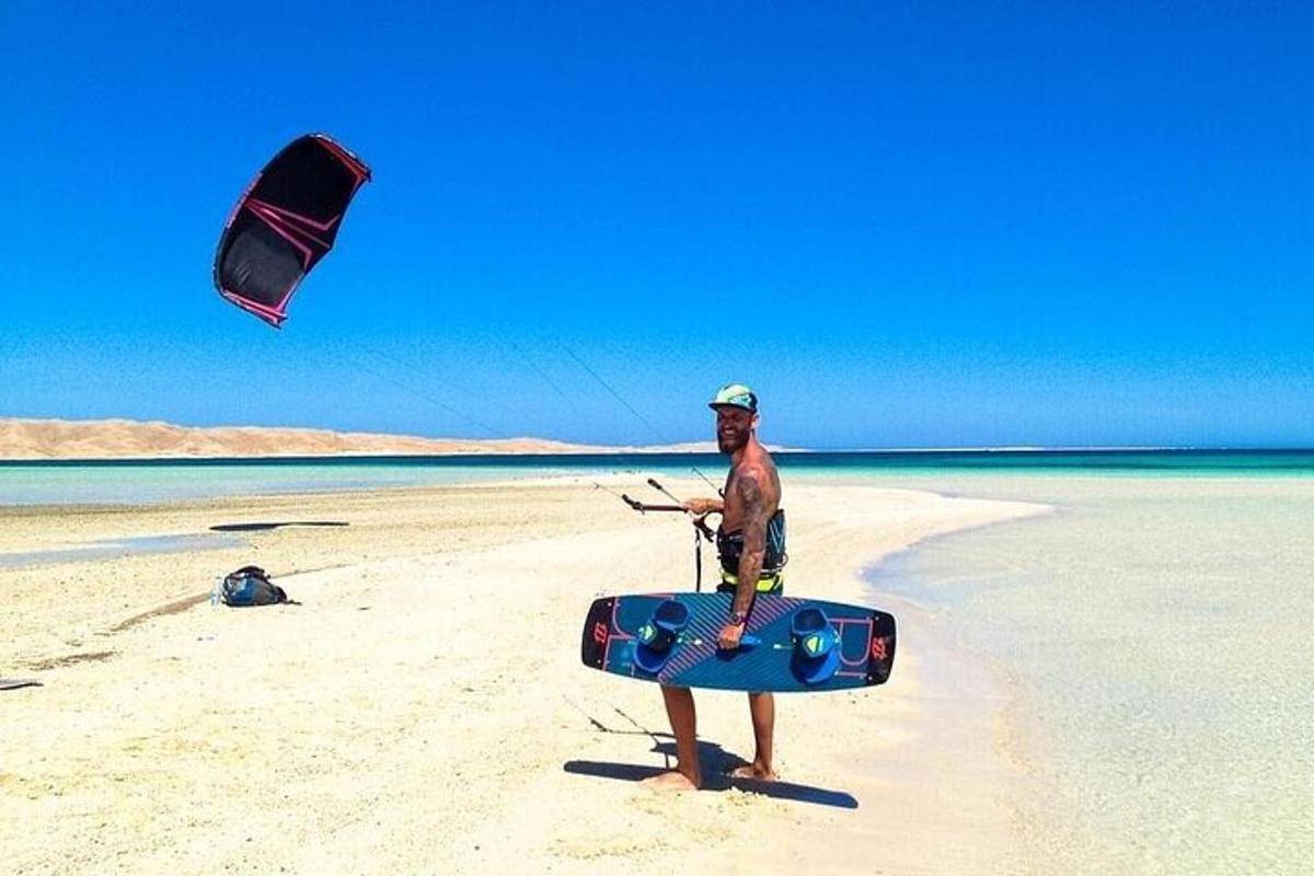 um homem parado na praia com uma pipa