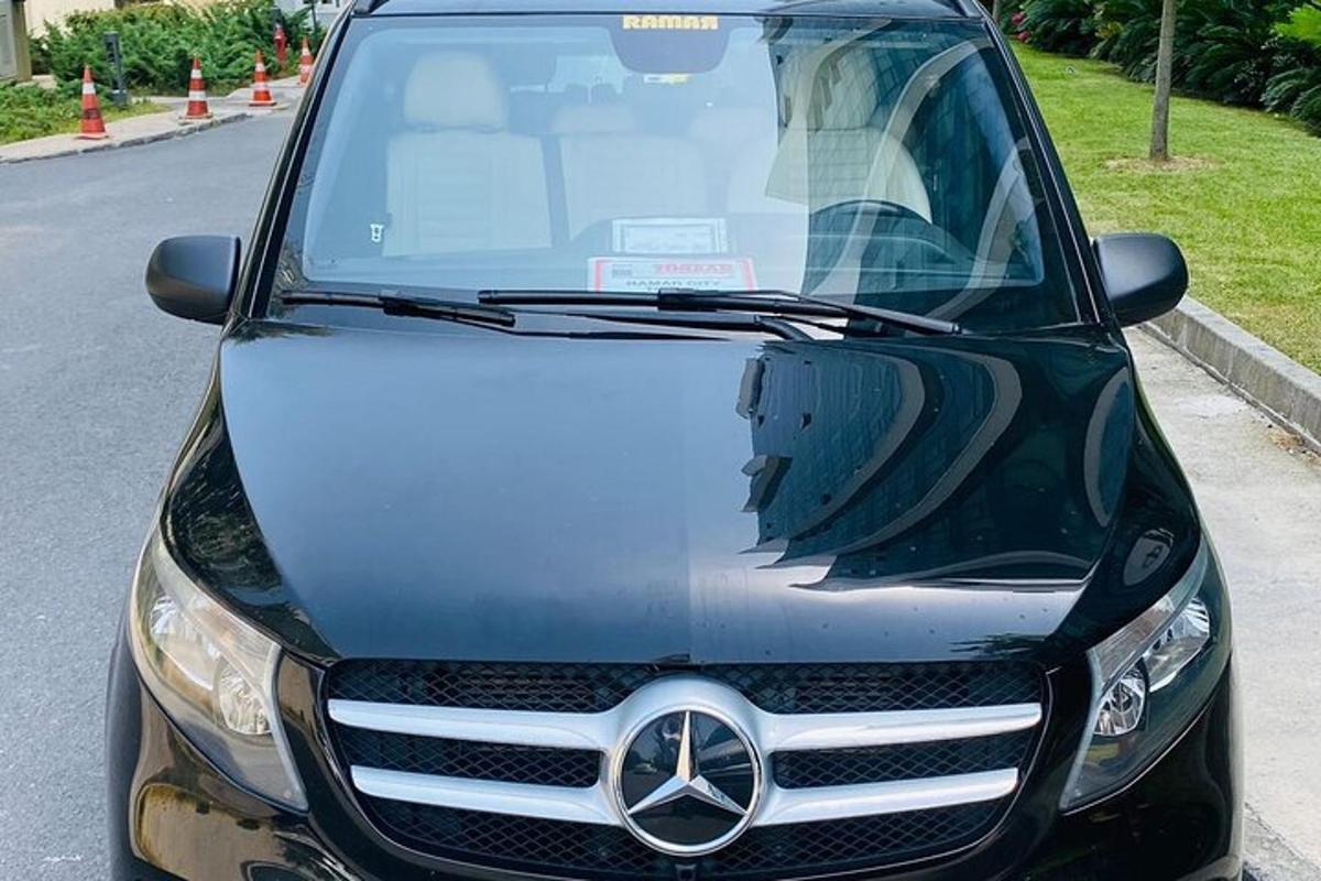 Un coche Mercedes Benz estacionado al costado de la carretera