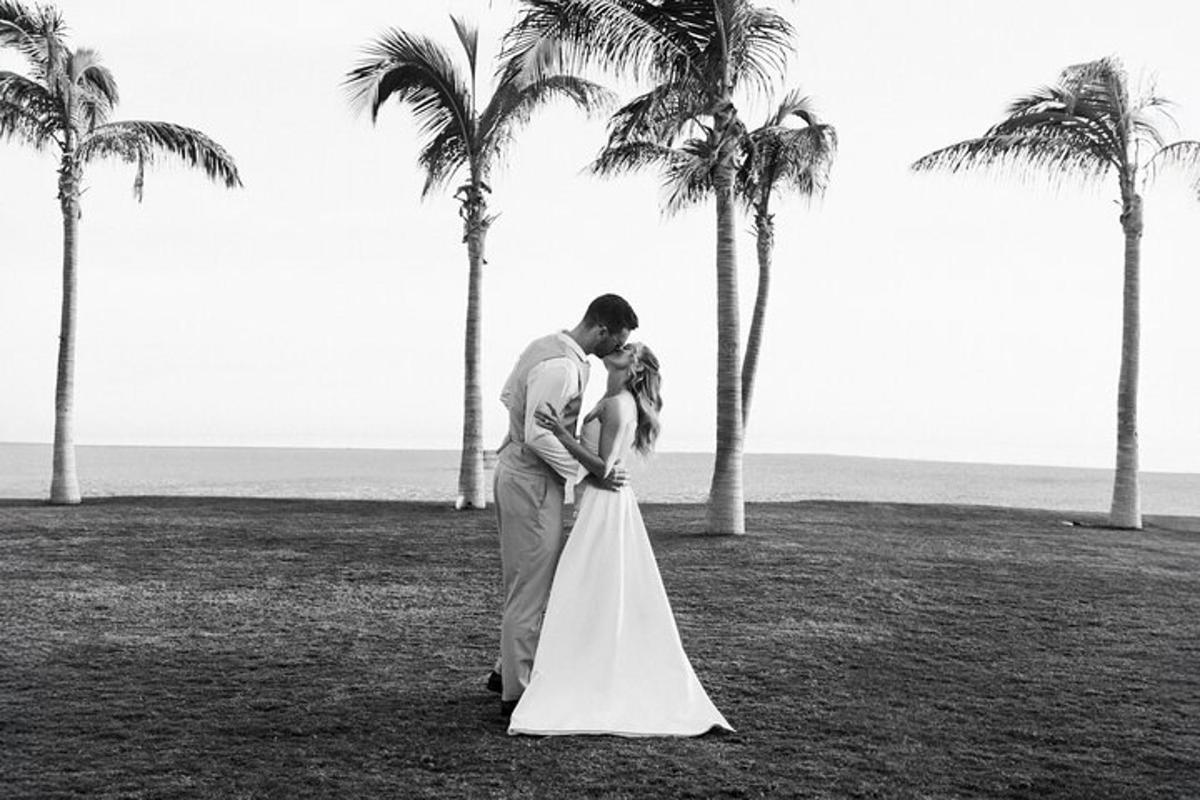 pasangan pengantin berdiri di hadapan pokok palma