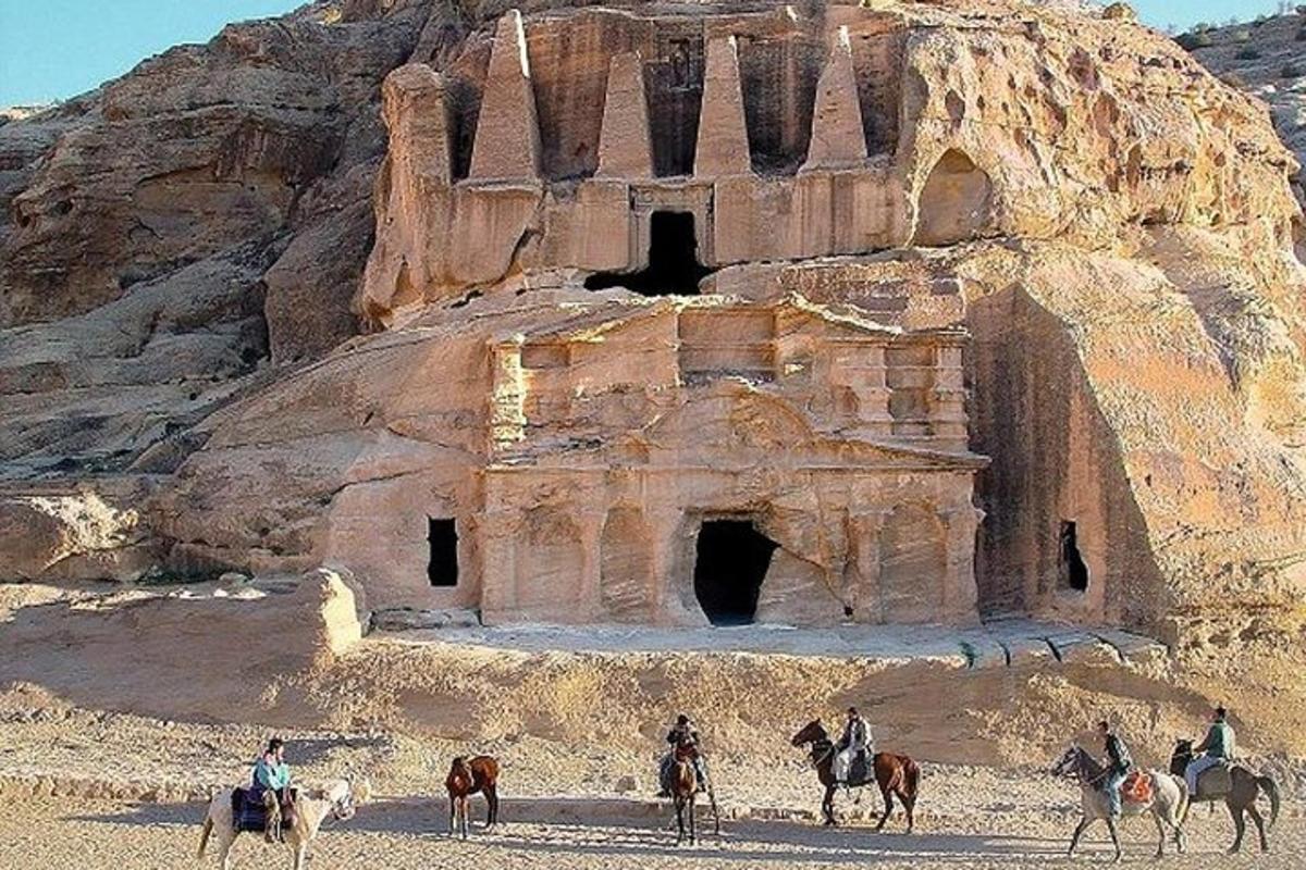 группа людей верхом на лошадях перед старинным зданием