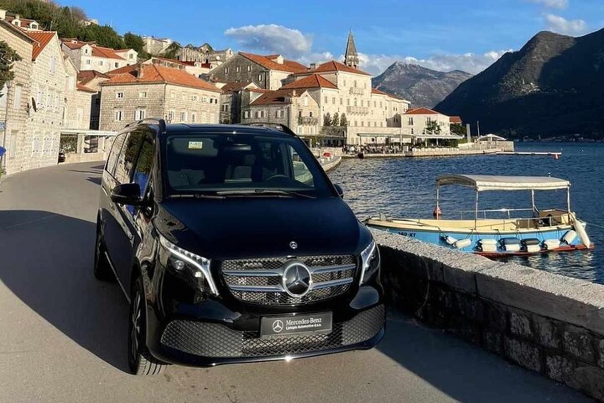 un'auto nera parcheggiata accanto a uno specchio d'acqua