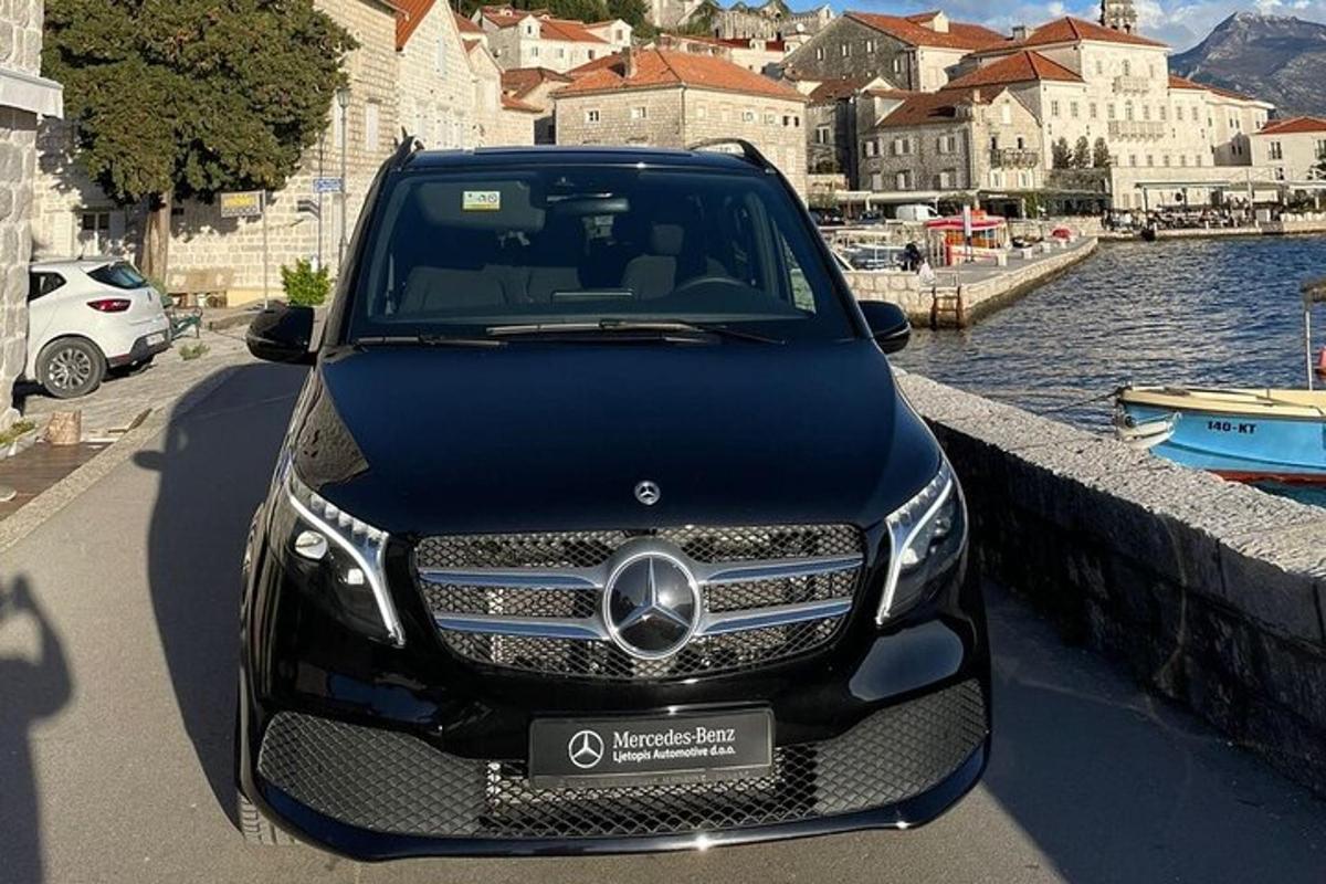un'auto nera parcheggiata accanto a uno specchio d'acqua