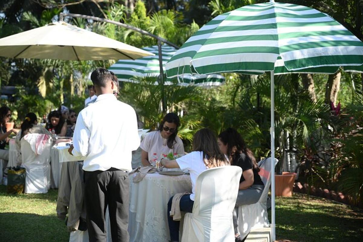 a group of people sitting at a table under an umbrella