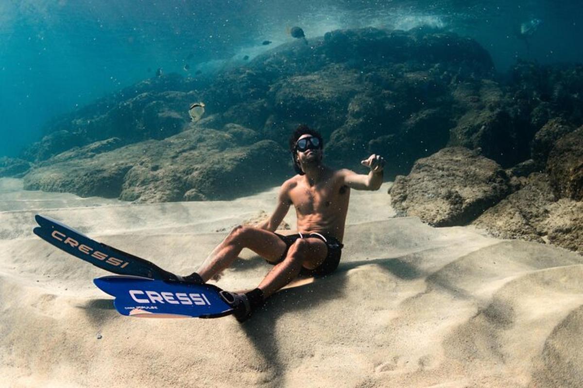 un uomo seduto sulla sabbia della spiaggia
