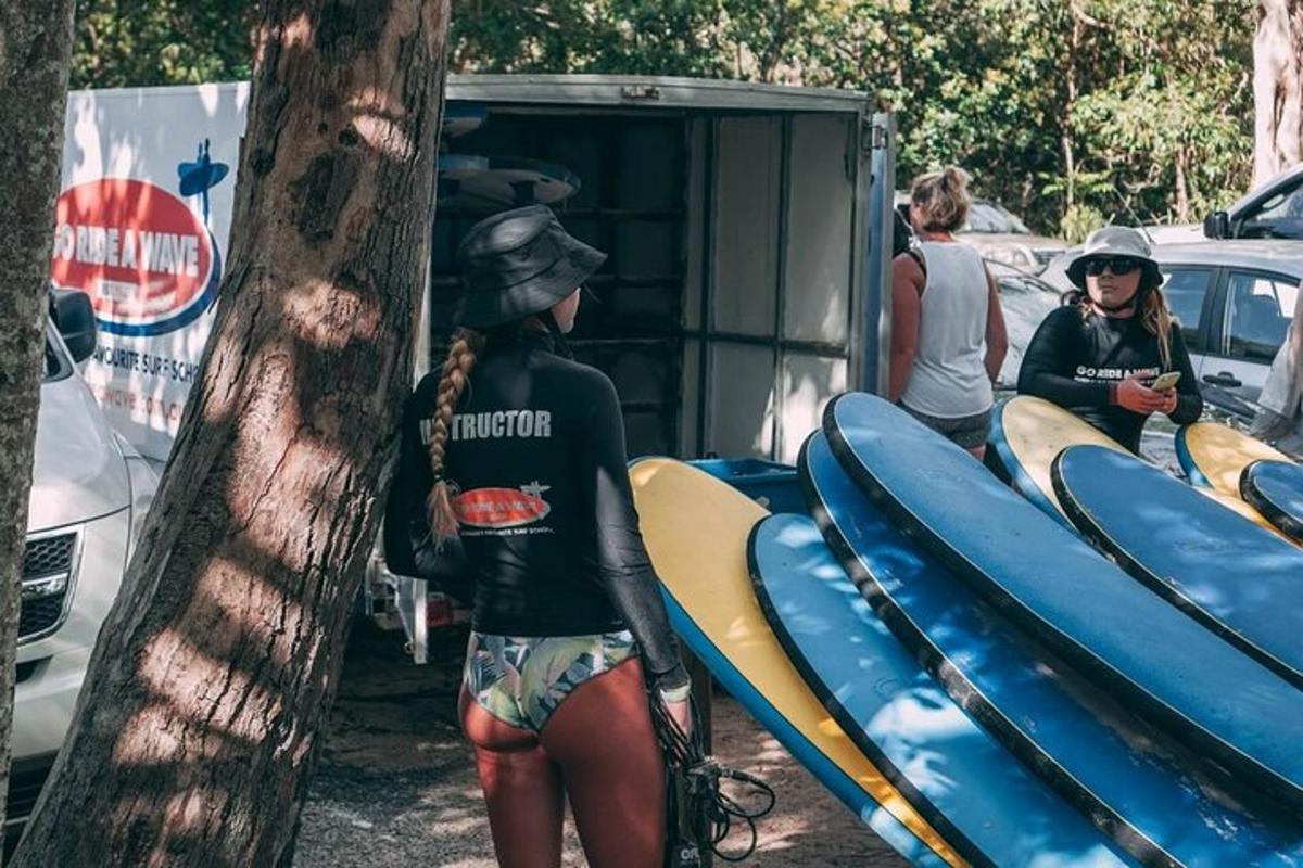 a woman is standing next to a tree with surfboards