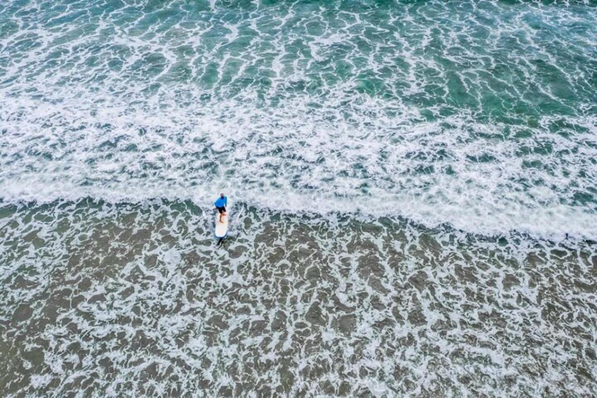 an overhead view of a person standing in the ocean