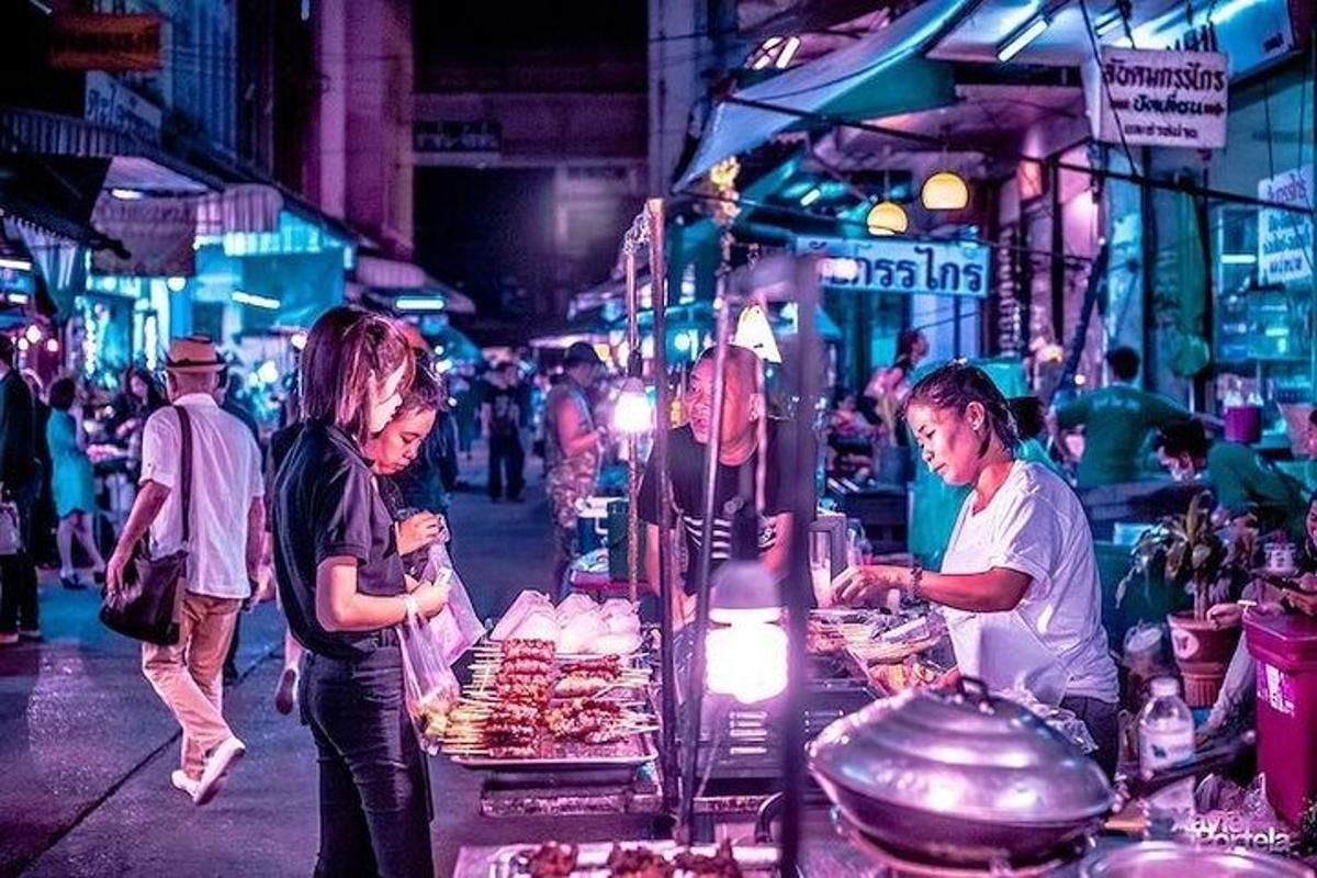 một vài người đang đứng ở một quầy hàng thực phẩm trong chợ