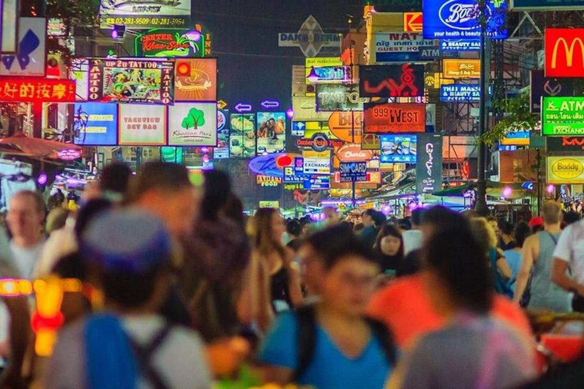 một đám đông người đi bộ trên một con phố đông đúc vào ban đêm