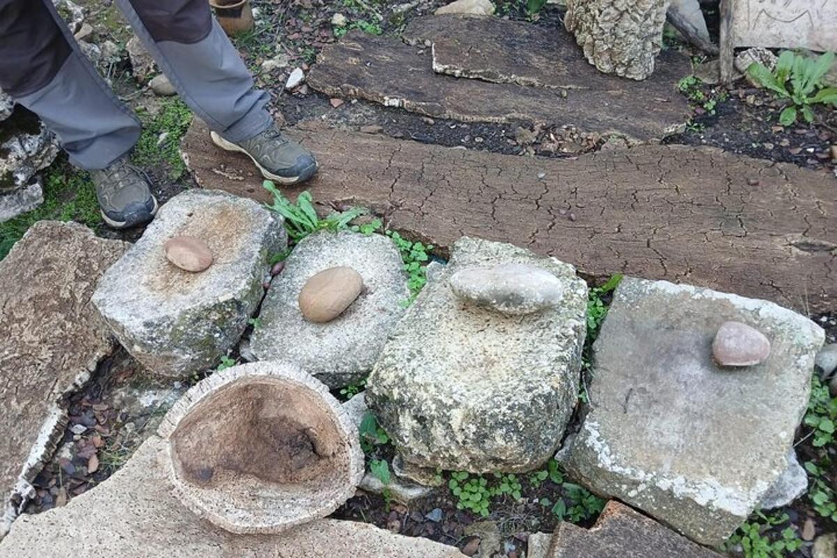 seseorang yang berdiri di sebelah beberapa batu di atas tanah