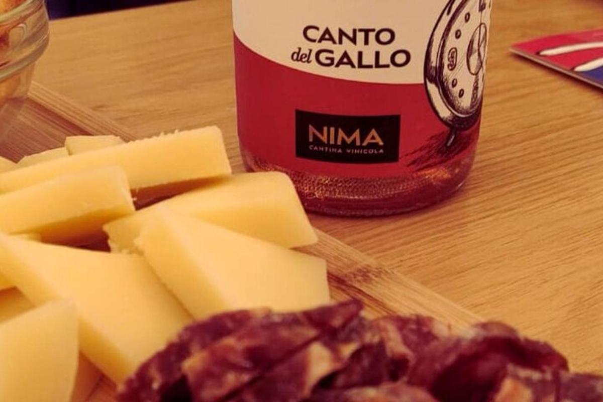 un tagliere con formaggio e una bottiglia di salsa