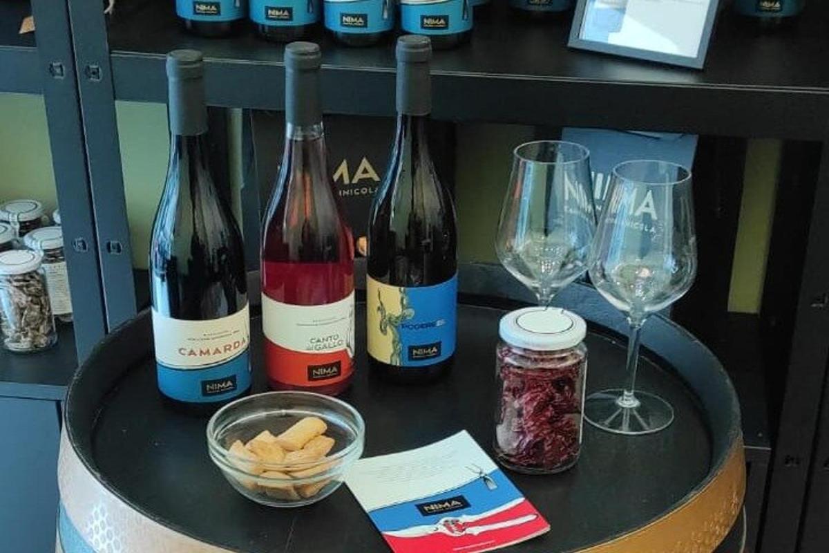 tre flasker vin og glass på et bord