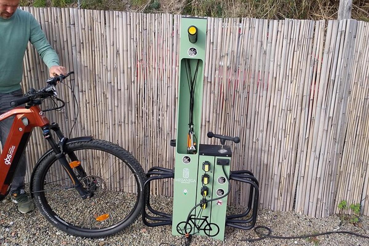 Un hombre parado al lado de una bicicleta al lado de un parquímetro.