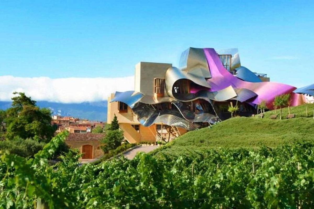 un edifici al cim d'un turó verd amb un edifici