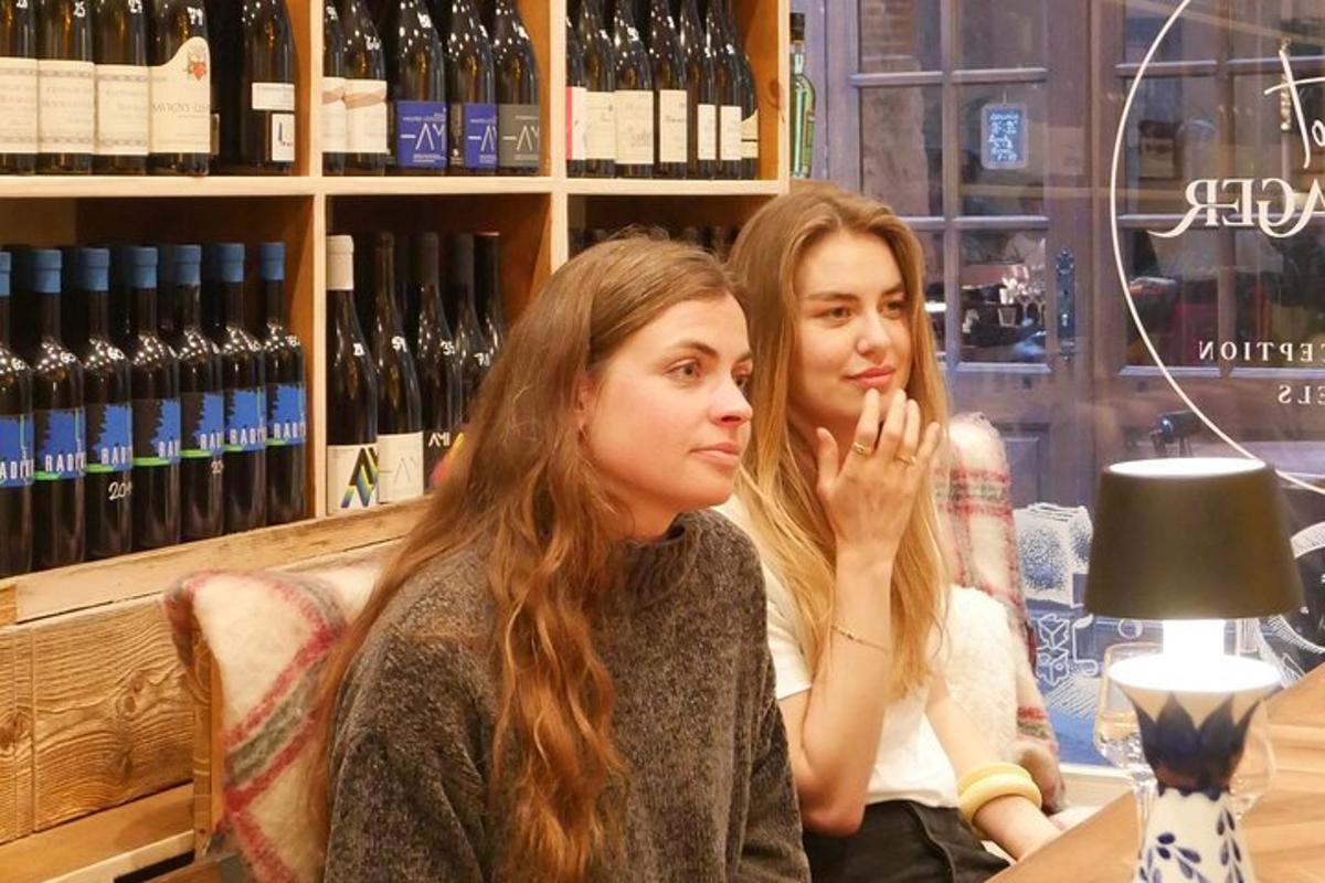 Dos mujeres sentadas en una mesa en una tienda de vinos.