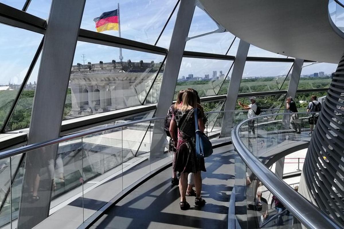una dona caminant per una passarel·la de vidre mirant el Louvre