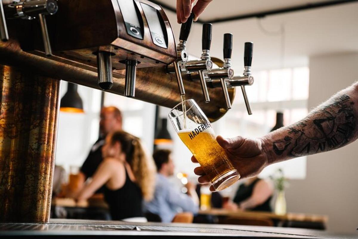 Una persona sostiene una cerveza en un bar.