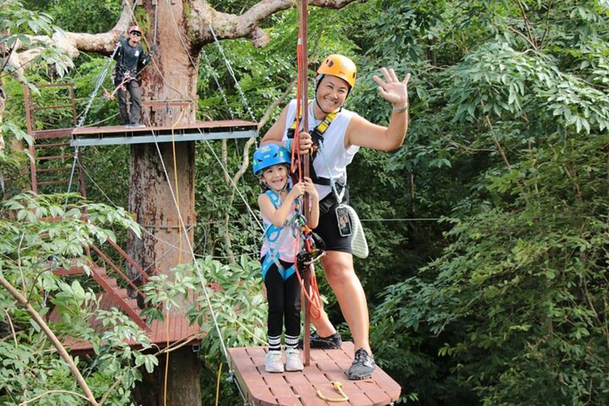 một người đàn ông và một đứa trẻ trên đường trượt zipline trong rừng