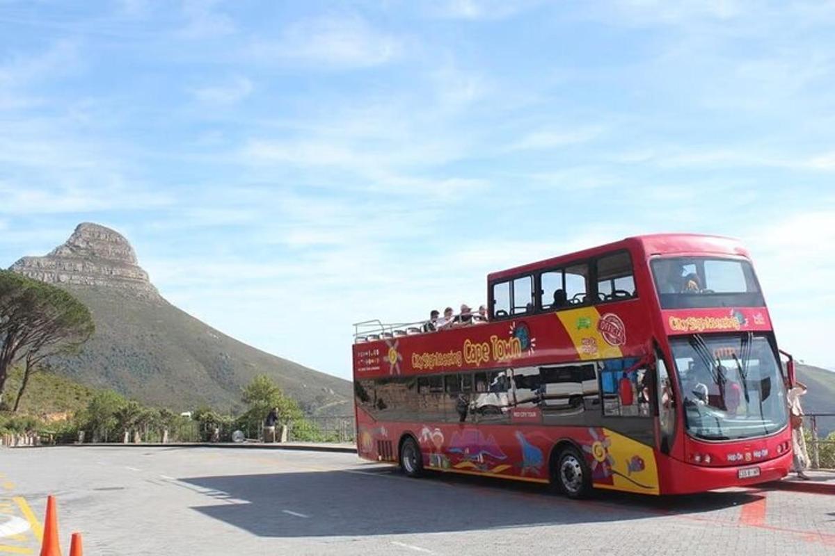 un autobuz roșu cu etaj parcat în fața unui munte