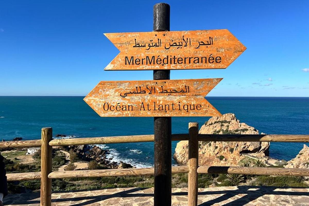 et gateskilt med tre skilt foran havet