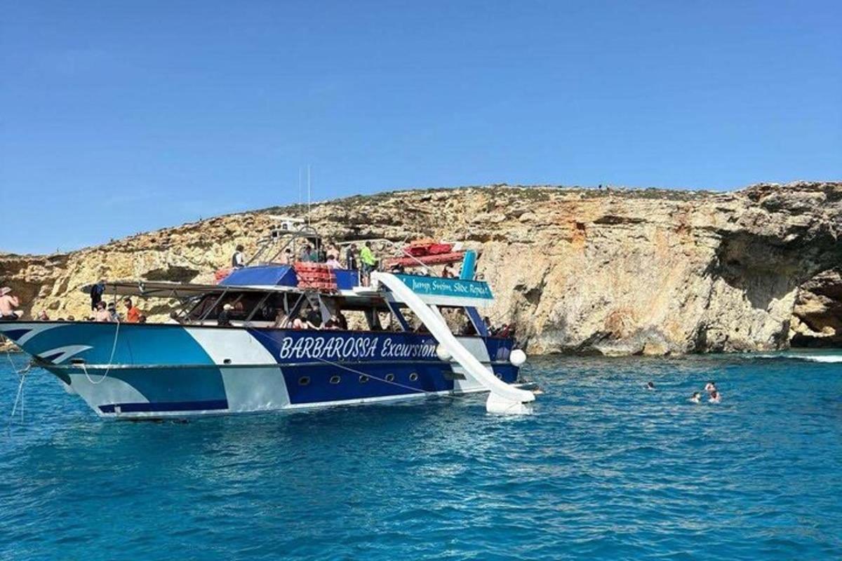a blue and white boat in the water with people on it