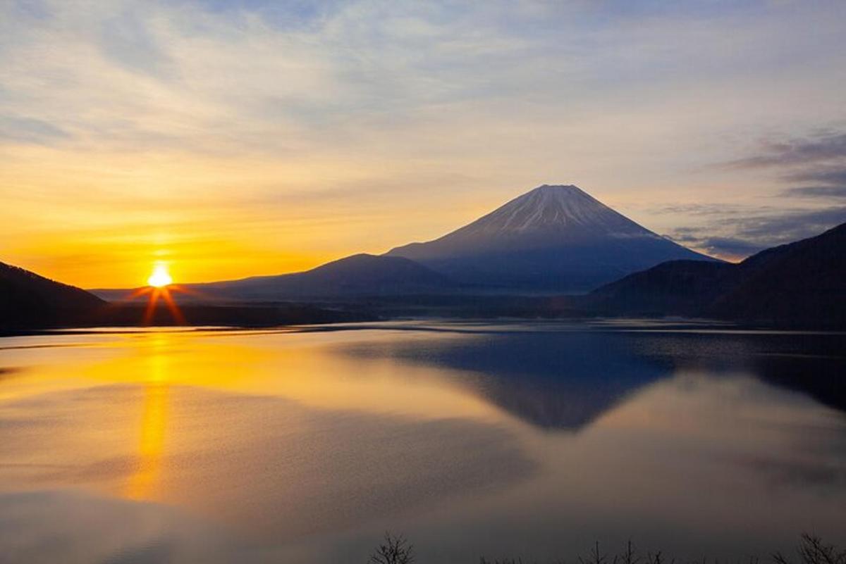una vista d'una muntanya al capvespre amb un reflex en un llac