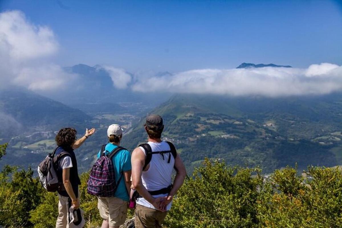 Un grupo de tres personas de pie en la cima de una montaña.