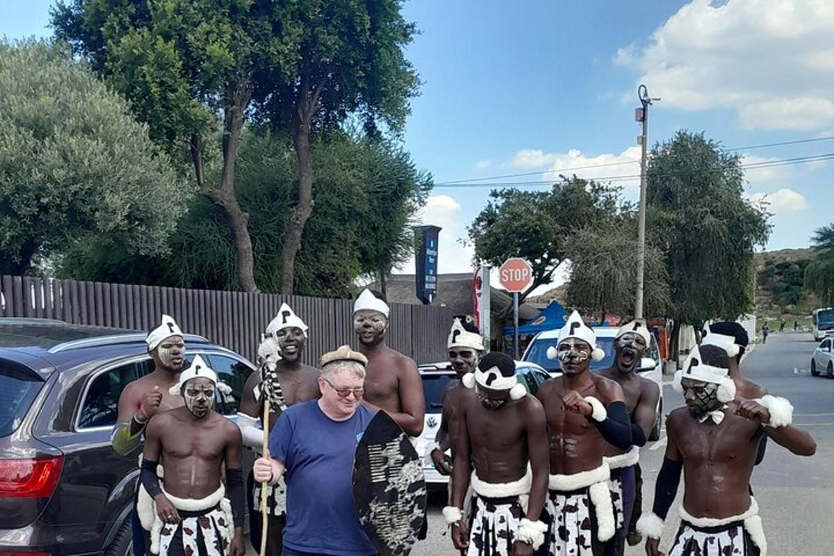 um homem parado na frente de um grupo de homens fantasiados