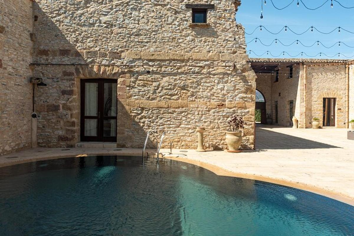 una piscina frente a un edificio de piedra
