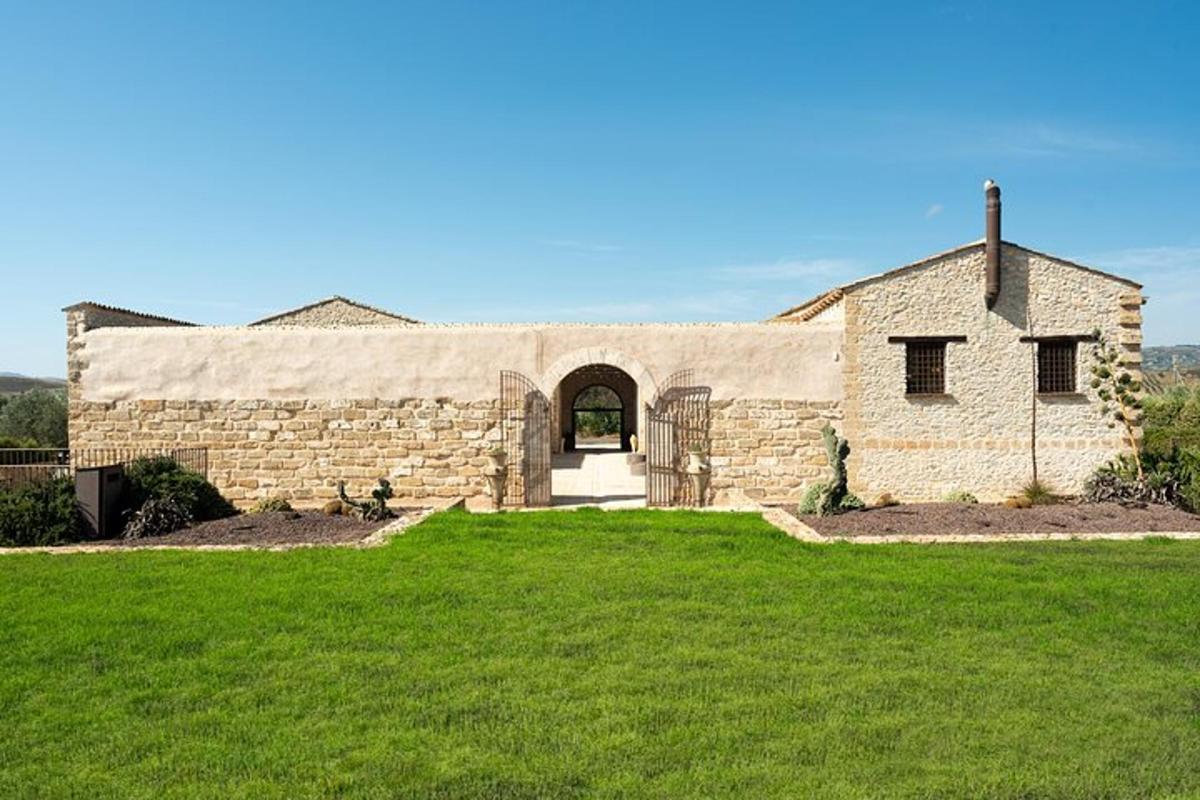 Un gran edificio de piedra con un campo de césped delante.
