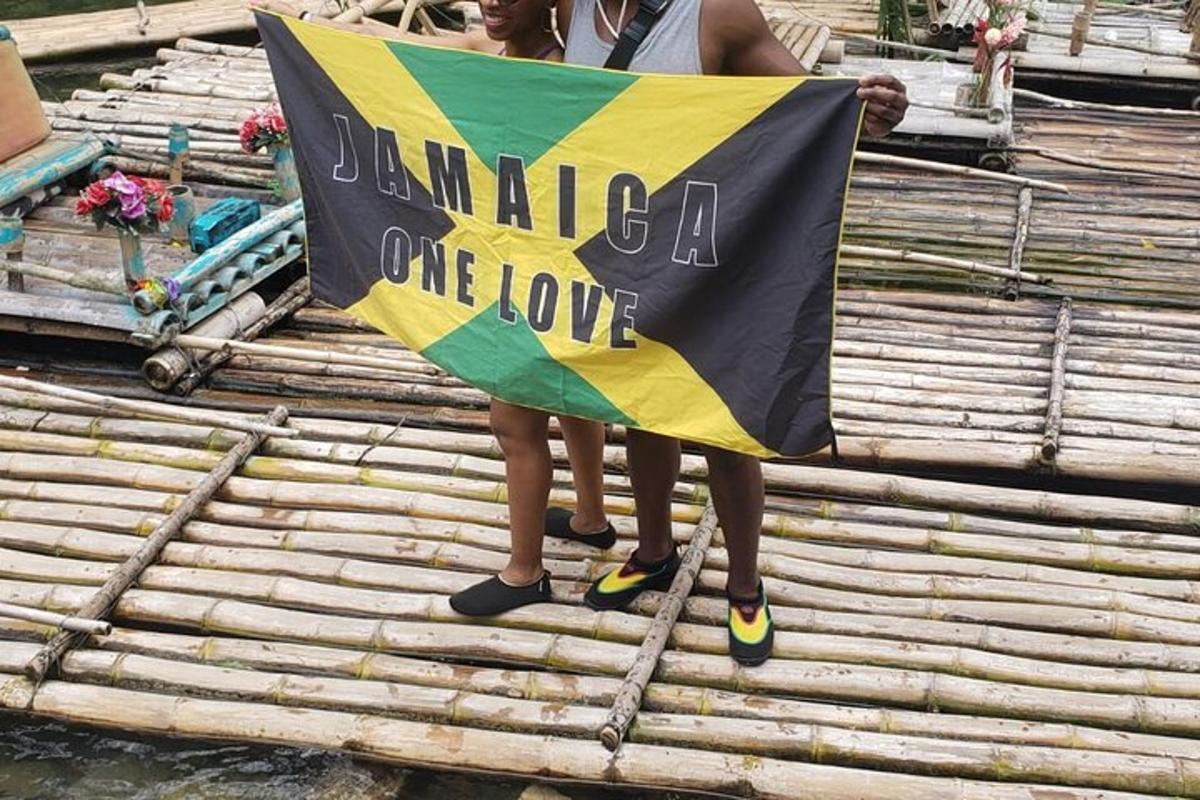 dua orang berdiri di atas rakit memegang bendera
