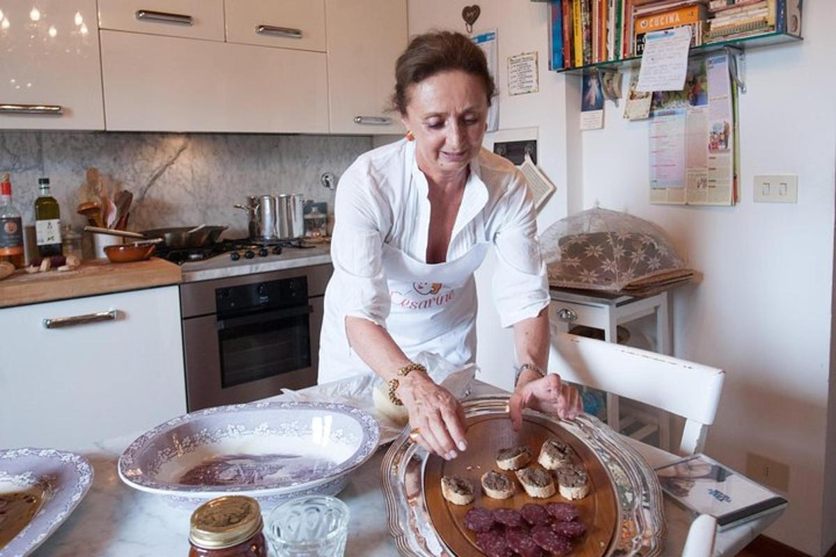 Una mujer en una cocina poniendo comida en una sartén.