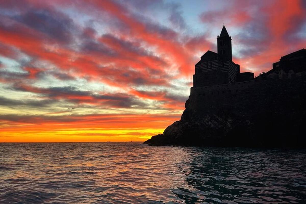 um castelo em uma rocha no oceano ao pôr do sol