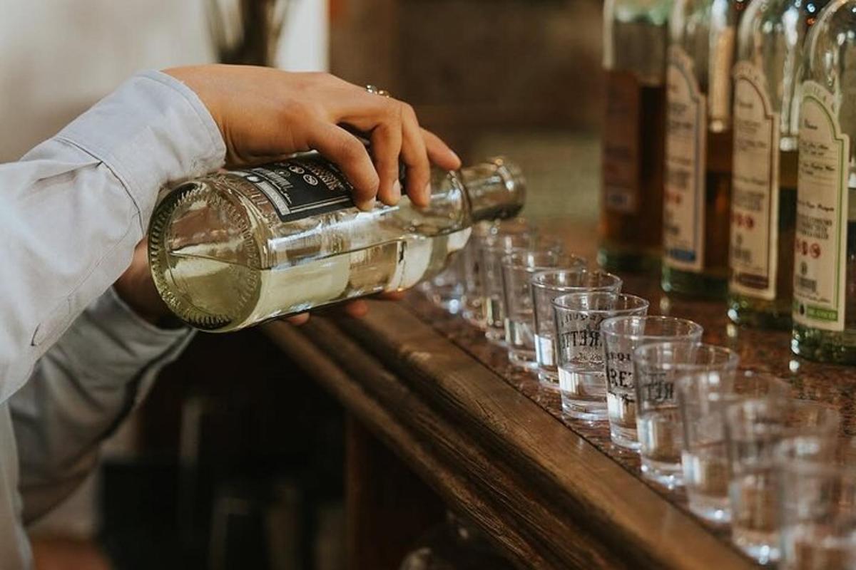una persona che versa un drink da una bottiglia su un bar