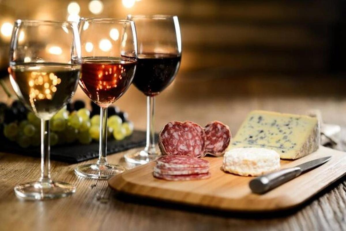 două pahare de vin și brânză pe o masă de lemn