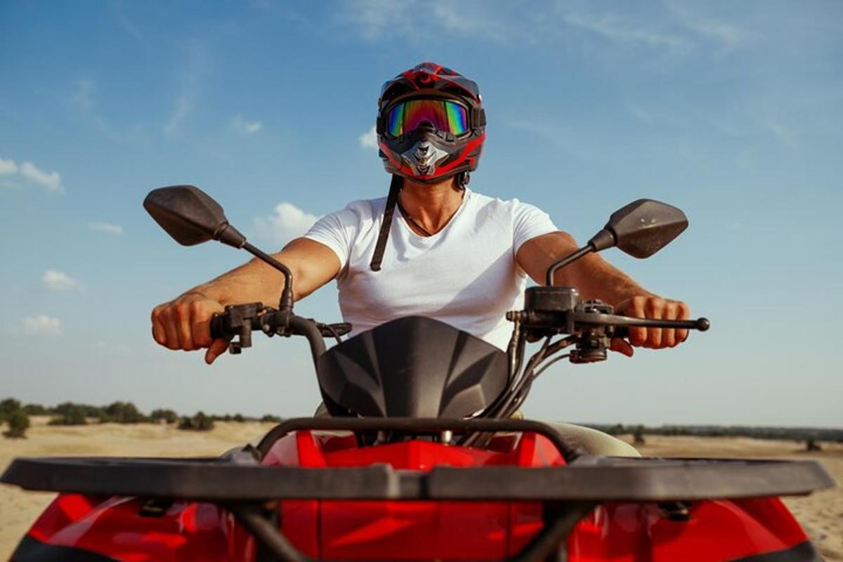 seorang lelaki memakai topi keledar di atas motosikal merah
