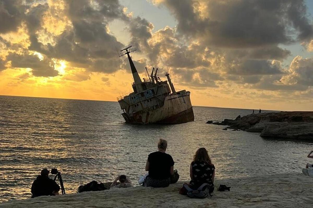 un gruppo di persone sedute sulla spiaggia vicino a una barca