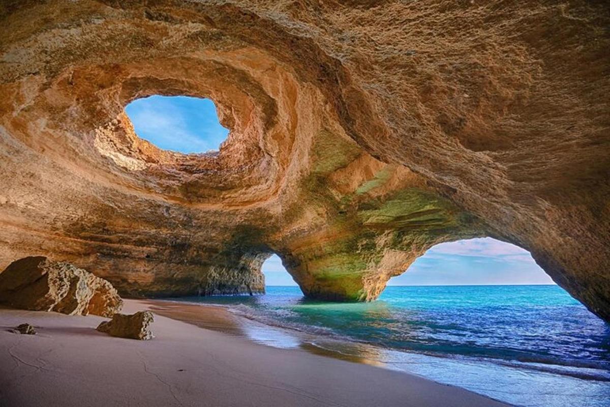 uma grande formação rochosa em uma praia com o oceano