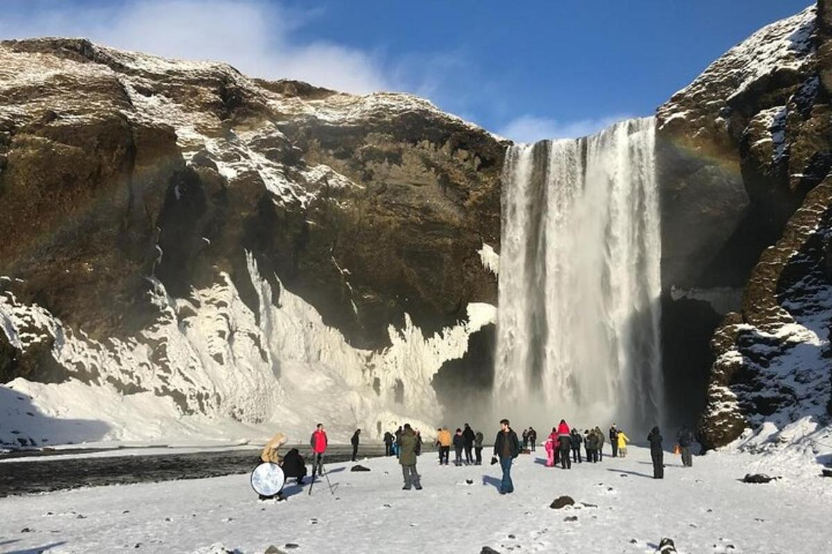 hópur fólks stendur fyrir framan foss