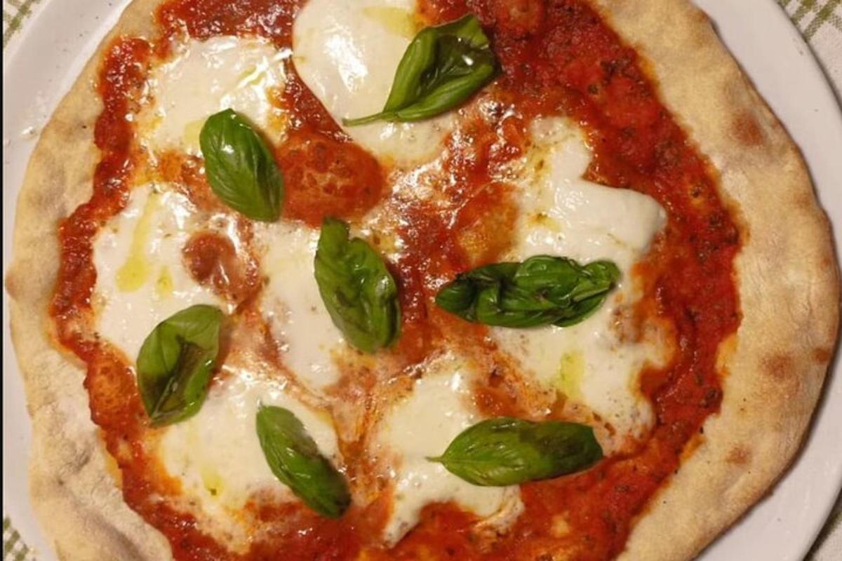 pizza se sýrem a bazalkou na talíři
