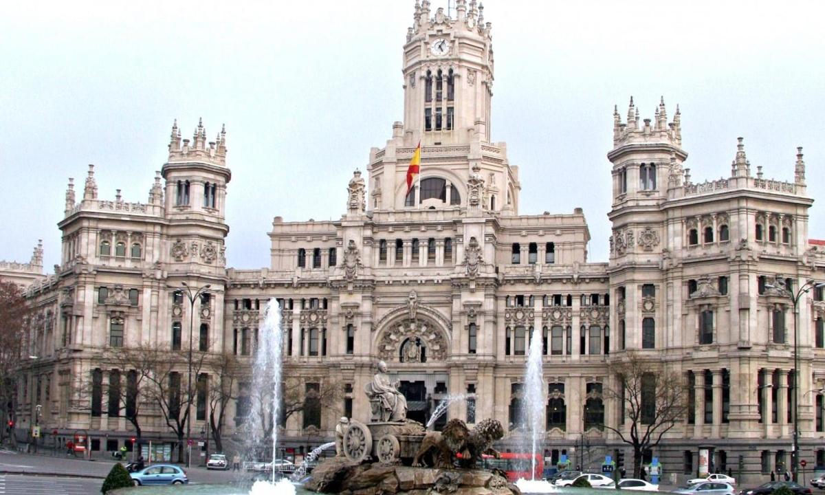 un grande edificio con una fontana di fronte