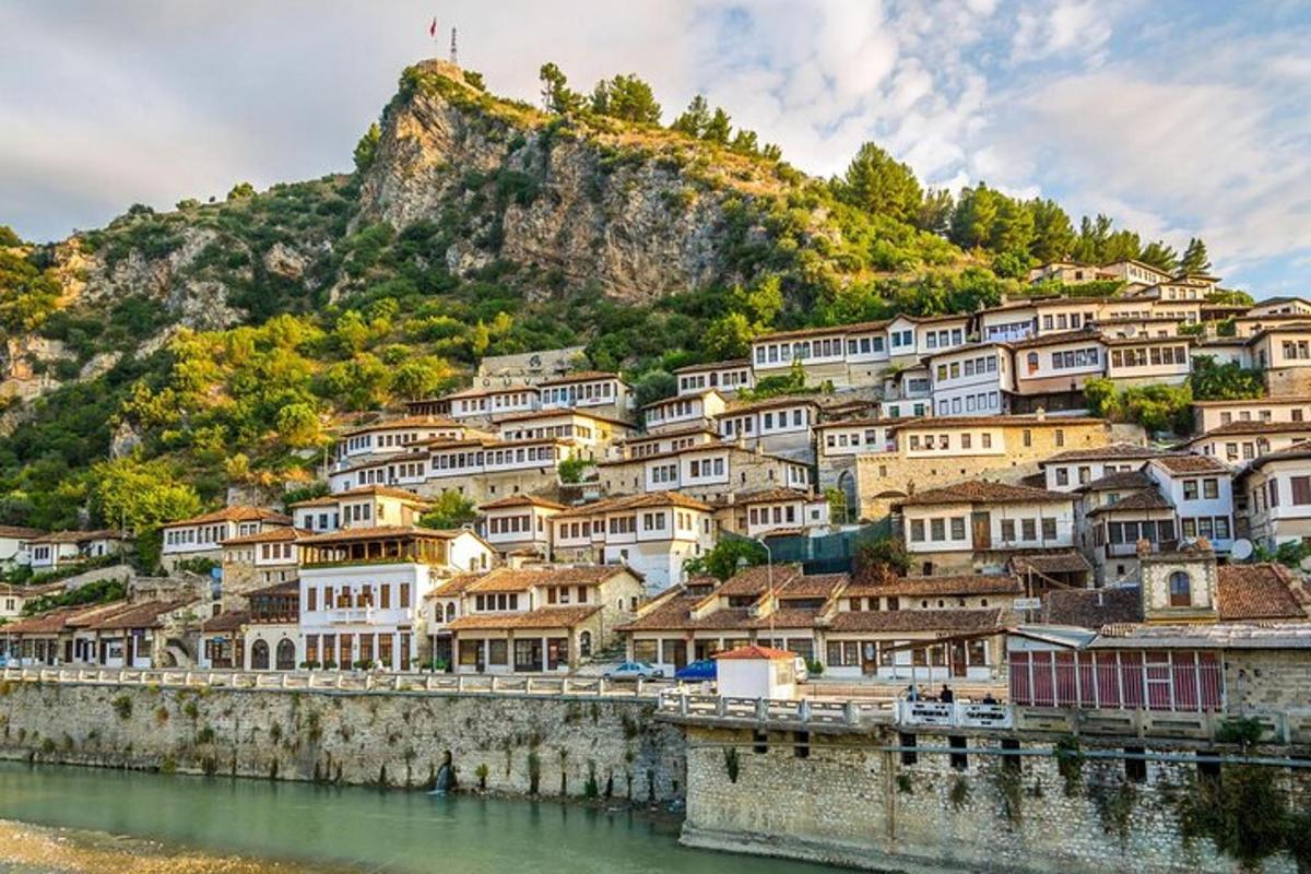 un pueblo en una colina al lado de un cuerpo de agua