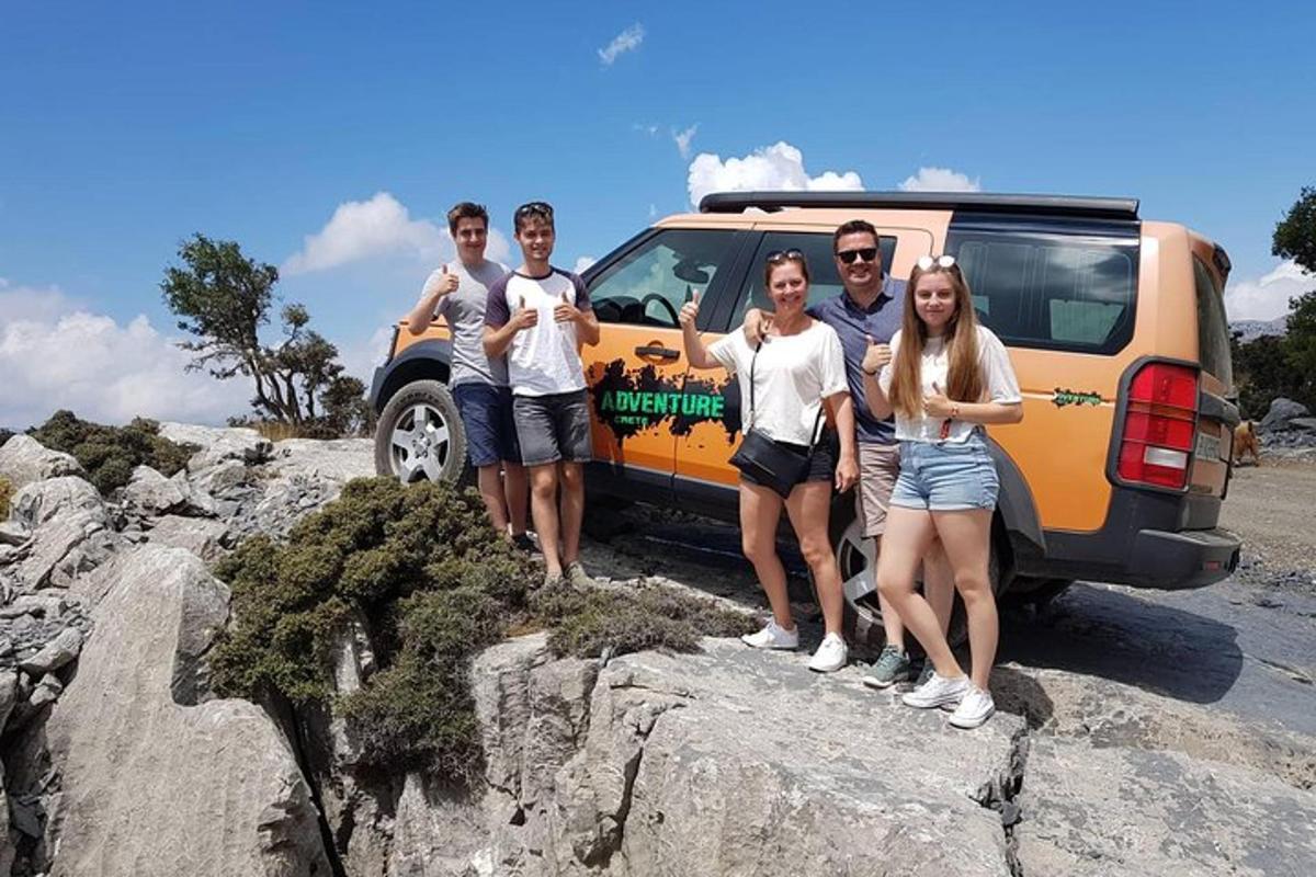 skupina lidí stojící na skále vedle dodávky